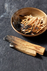 occult science and supernatural concept - palo santo sticks and cup with burnt matches