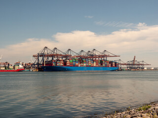 Rotterdam harbor big ship with containers and cranes on dock
