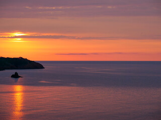 Magnigique lever de soleil derrière un rocher sur la Côte d'Azur.