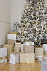 beautiful decorated Christmas tree with gifts under it in a luxury apartment decorated for the new year