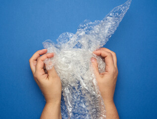 female hand holding crumpled piece of polyethylene with air bubbles