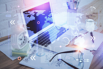 Double exposure of desktop with computer and world map hologram. International data network concept.