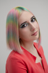 Portrait of a young beautiful informal blonde girl with dyed hair. Red jacket suit on the naked body. Studio photoshoot on a white background.