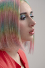 Portrait of a young beautiful informal blonde girl with dyed hair. Red jacket suit on the naked body. Studio photoshoot on a white background.