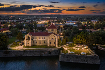 Fototapeta premium Tata, Hungary - Aerial view of the beautiful illuminated Castle of Tata by the Old Lake (Öreg-to) at dusk with colorful sunset clouds on a summer night
