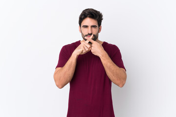 Young handsome man with beard over isolated white background showing a sign of silence gesture