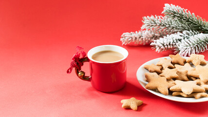 Red cup with coffee and a plate of gingerbread cookies on a red background. Christmas concept.