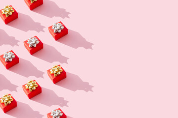 Pattern red gift of pastel pink background. Holiday concept new year or Christmas gift box presents Xmas. Trendy Minimal composition. Flat lay. Top view. Copy space.