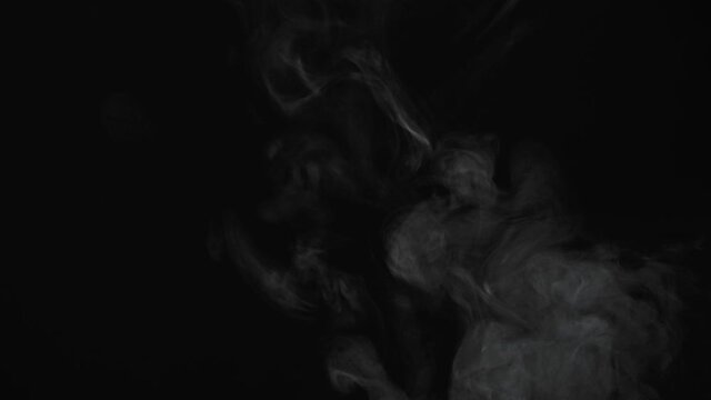 unhealthy lifestyle .  cigarette  smoke clouds draws artistic abstract patterns. dark background 