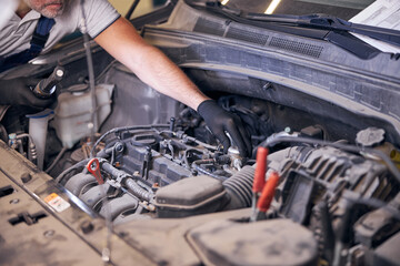 Fototapeta na wymiar Auto mechanic fixing car engine at service station