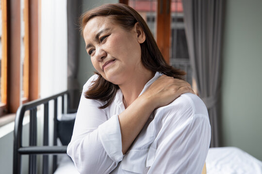 middle aged southeast asian woman suffers from shoulder joint pain or osteoporosis