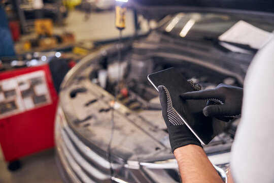 Male worker using tablet computer at auto repair station