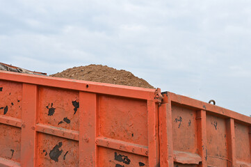 Raised bucket of a truck, unloading sand