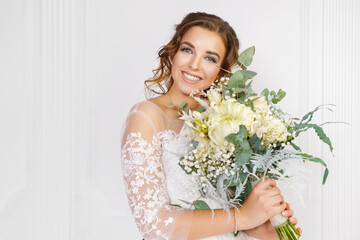  Beautiful young bride with wedding bouquet on light background