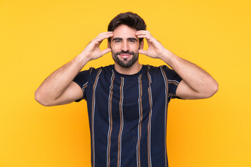 Fototapeta premium Young handsome man with beard over isolated yellow background unhappy and frustrated with something. Negative facial expression