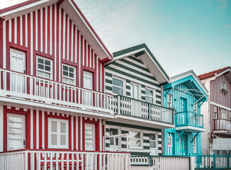 Obraz premium Tradittional fishermen's colorful houses in Costa Nova, Aveiro, Portugal. Tourism atraction. Red , green and blue stripes