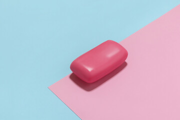 Pink soap bar on blue and pink background.