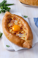 Khachapuri in Adjarian or Adjara khachapuri, boat, national Georgian cuisine, pastry with cheese and egg.