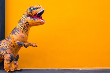 one big and tall dinosaur enjoying and having fun with orange background - copy and blank space to...