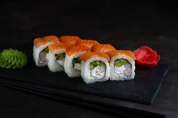 Rolls with avocado, shrimp, cream cheese and salmon on a black background