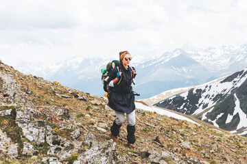 Traveling Woman tourist with backpack hiking in mountains