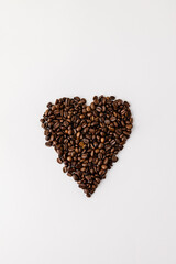 Coffee beans in shape of heart on white background, flat lay