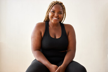 plump, plus size african american young woman in sportswear sit looking at camera, in studio over...