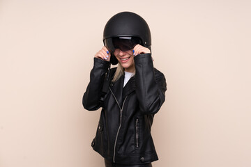 Young blonde woman with a motorcycle helmet over isolated background