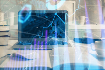 Stock market graph on background with desk and personal computer. Multi exposure. Concept of financial analysis.