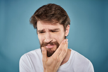 Naklejka premium Bearded man displeased facial expression emotions close-up blue background white t-shirt