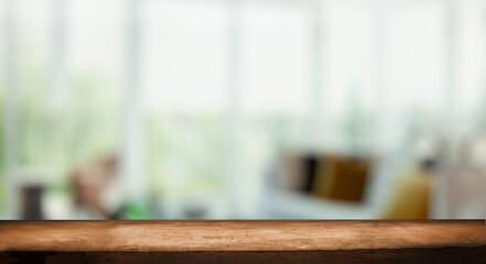 The top of the wooden table on the blur of the windowpane. Green color from a vegetable garden on the morning background. For product montage display.