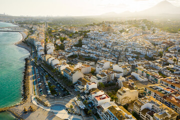Picturesque view from drone of white buildings with brownish tiled roofs of Spanish tourist town of Altea on Mediterranean coast in summer..