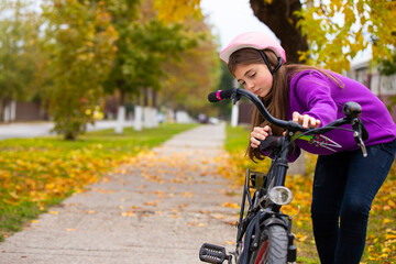 Fototapeta na wymiar A girl with a bike in the park, resting after a bike ride. Bright colors of autumn. High quality photo
