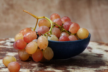 Bunch of pink grapes over rustic background