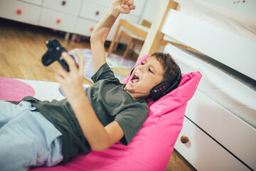 Little boy with gamepad playing video game at home © Mediteraneo