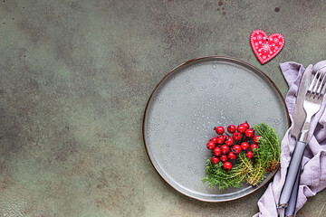 Christmas table setting with festive decorations on green background with copy space. Holidays background. Top view, flat lay.
