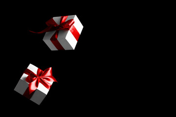 Discount background. White gifts with red bow falling on black background for Black Friday banner. Flying backdrop with space for text.