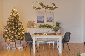 A glass of champagne in the background of the Christmas table and the lights of the Christmas tree