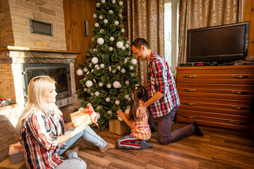 family and christmas tree in an old wooden house