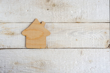 Toy house, on a wooden background. Housing and real estate concept