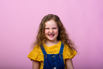 Happy carefree emotions. Energetic joyful adorable little girl laughing at joke on pink background.