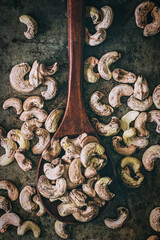 Raw unpeeled cashew nuts on a dark background