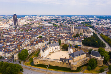 Fototapeta na wymiar Drone view of ancient Chateau des ducs de Bretagne and Nantes Cathedral on background of downtown with modern skyscraper in summer, France..