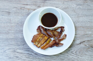 grilled slice pork neck and skin dipping spicy sauce on plate