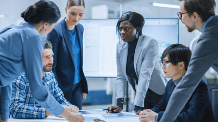 Busy Diverse Team of Computer Engineers and Specialists Gather Around Conference Table, They...