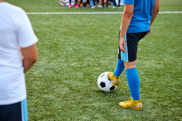 Obraz premium sportive child boy in uniform kicking ball, they have penalty in this round. kids play football, competition in stadium, in field