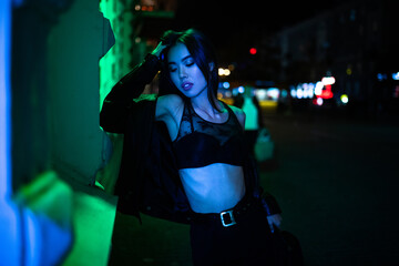 Fototapeta na wymiar Woman poses in night city against lights background.