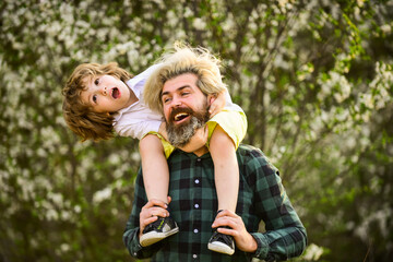 Weekend with family. happy family day. spring is coming. just have fun. love concept. father playing with his child in park. Handsome dad with his little cute son. enjoy bloom and nature together