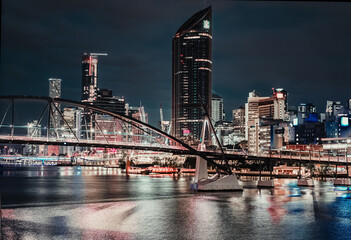 Obraz premium Vie of the steel modern bridge over the river that runs among skyscrapers of the city CBD on creative colour grading