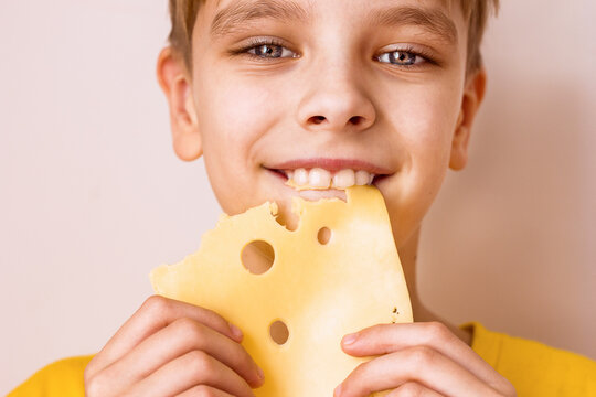 Boy biting a piece of cheese portrait close-up